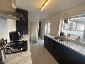 a kitchen with a stove and a sink and a window at Private double room in our Cardiff Home in Cardiff