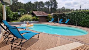 - une piscine avec des chaises, une table et une table dans l'établissement La Villa du Marensin, à Lit-et-Mixe