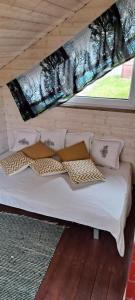 a white bed in a room with a window at Cottage Kesäranta in Kumia
