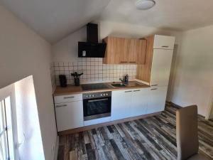 a kitchen with white cabinets and a sink and a stove at Ferienwohnung in Nordhausen