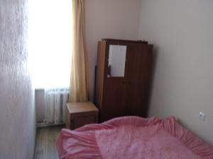 a bedroom with a bed and a dresser and a window at Квртира в центре города Севан, in Sevan