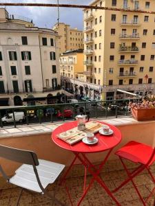 a red table and chairs on a balcony with buildings at Big house al centro di Roma in Rome