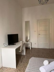 a white room with a desk with a television on it at Big house al centro di Roma in Rome