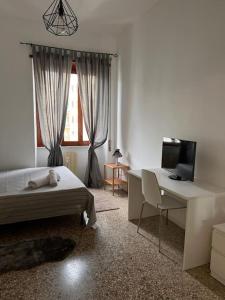 a bedroom with a bed and a desk and a television at Big house al centro di Roma in Rome