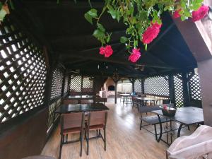 Casa Cu Pridvor في بايلي فيليكس: غرفة بها طاولات وكراسي وزهور على السقف