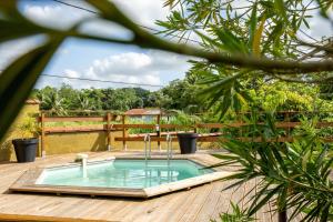 a pool on a wooden deck with a hot tub at La Villa Holiday, 10 personnes, piscine patio bar terrasse in Sainte-Rose
