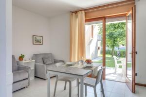 een woonkamer met een tafel en stoelen en een raam bij Residence Villaggio Tiglio in Sirmione