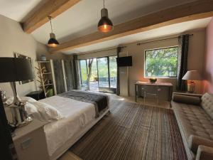 een slaapkamer met een bed, een bureau en een raam bij Hôtel La Maison de Crillon in Crillon-le-Brave