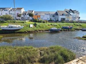 two boats are docked in a river with houses at Diamond Lodge in Millom