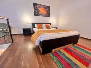 ein Schlafzimmer mit einem großen Bett und einem bunten Teppich in der Unterkunft Riviera Foothills, Arpora in Arpora