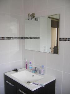 a bathroom with a white sink and a mirror at Maison tout confort Figeac in Figeac +7 photos