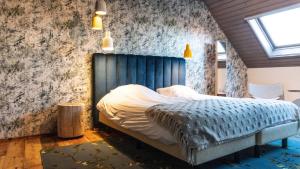 een slaapkamer met een bed met een blauw hoofdeinde bij Erfgoed Bossem in Lattrop