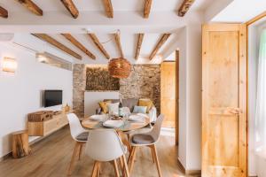 ein Esszimmer und ein Wohnzimmer mit einem Tisch und Stühlen in der Unterkunft Casa do Tio Farinha by RNvillage in Sesimbra