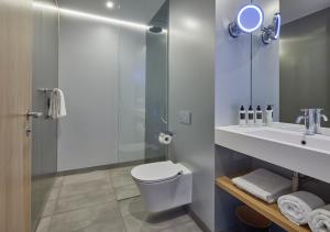 a bathroom with a toilet and a sink and a mirror at Hotel Arsenaal Delft in Delft +34 photos