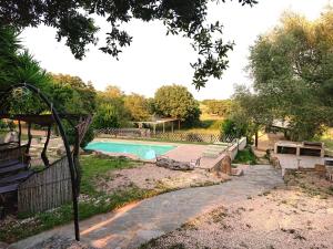 a swimming pool in a yard with a fence at Agriturismo Desole in Monti