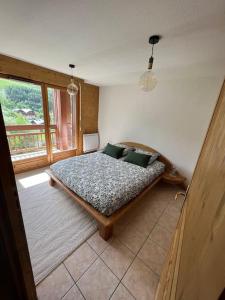 a bedroom with a bed in a room with a window at Appartement pied des pistes avec garage et balcon- Balcons des Pistes in Les Deux Alpes