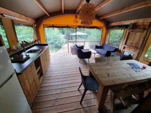 a kitchen and dining area of a tiny house at SUZE LUXE NATURE in Suze-la-Rousse