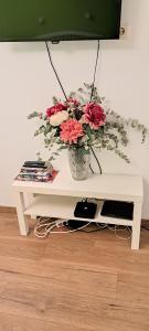 une table blanche avec un vase de fleurs sur elle dans l'établissement MKR Family Room, à Zagreb
