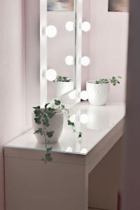 two plants sitting on a white counter with a mirror at Ruby Apartment in Agios Nikolaos +24 photos