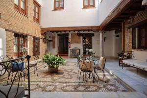 a patio with chairs and a table in a building at Charminghomesgranada Aljibe Granadino in Granada