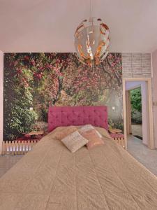 a bedroom with a large bed and a wall with flowers at Ruby Apartment in Agios Nikolaos