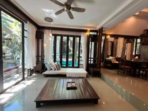 a bedroom with a bed and a table in a room at KhgeMa NuanJun Pool Villa Gallery Resort in Ban Huai Yai