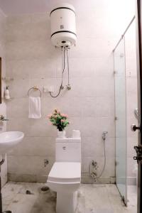 a bathroom with a toilet with flowers on it at Divine India Service Apartment 1bhk, D-198,UGF in New Delhi
