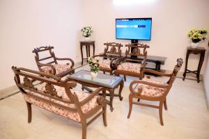 a living room with chairs and a table and a television at Divine India Service Apartment 1bhk, D-198,UGF in New Delhi