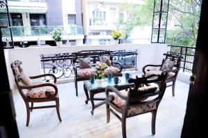 a patio with four chairs and a table and a couch at Divine India Service Apartment 1bhk, D-198,UGF in New Delhi