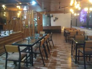 une salle à manger avec des tables et des chaises ainsi qu'un bar dans l'établissement Panambi Tapovan Resort, à Rishikesh