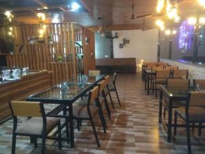 un comedor con mesas y sillas y un bar en Panambi Tapovan Resort, en Rishīkesh