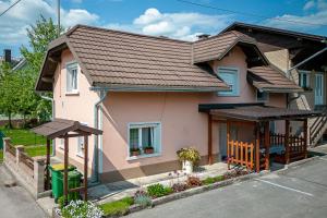 una pequeña casa rosa con techo marrón en Pool House Mržek Family Friendly - Happy Rentals en Nova Vas