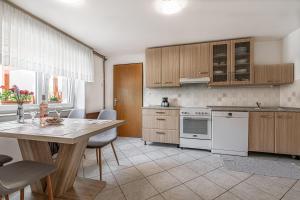 a kitchen with white appliances and a table with chairs at Pool House Mržek Family Friendly - Happy Rentals in Nova Vas