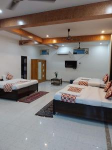 a room with two beds and a flat screen tv at Panambi Tapovan Resort in Rishīkesh