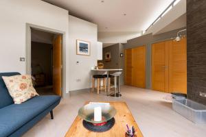 a living room with a blue couch and a table at The Studio House - Crouch End in London