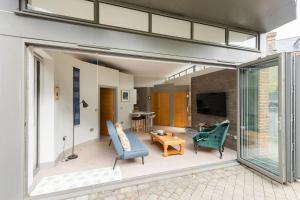 a living room with sliding glass doors and a table at The Studio House - Crouch End in London