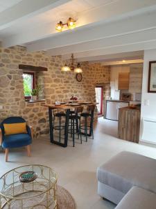 a kitchen and living room with a stone wall at Le Domaine de la petite chèvre in Ploumagoar
