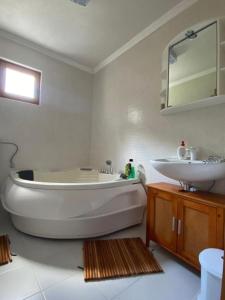 a white bathroom with a tub and a sink at Villa Green Heaven in Sarajevo