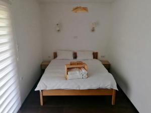 a small bedroom with a bed with a wooden table on it at Villa Green Heaven in Sarajevo