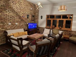 Villa Green Heaven في سراييفو: غرفة معيشة مع كراسي وجدار من الطوب