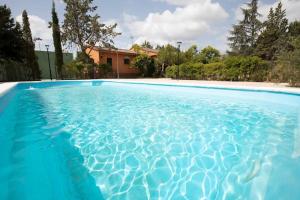 uma piscina com água azul em frente a uma casa em Finca el Palomar de la Viña em Madri