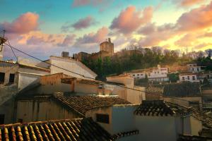 a view of roofs of buildings with a castle in the background at Charminghomesgranada Aljibe Granadino in Granada