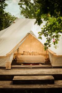 a white tent with a bed in it at Glamping Hive 