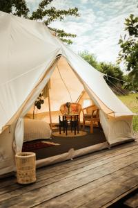a tent with a table and chairs on a deck at Glamping Hive 