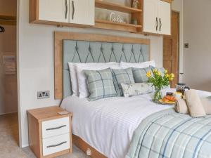 a bedroom with a large bed with a blue headboard at Lake View - Uk36811 in Whalley
