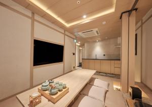- un salon avec un canapé et une télévision dans l'établissement UH Suite Central Seoul, à Séoul