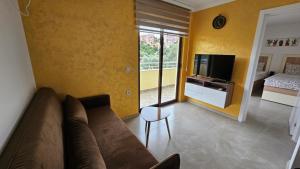- un salon avec un canapé et une télévision dans l'établissement Apartments Val Maslina, à Utjeha-Bušat