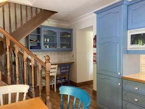 Apartment 447 - Ballynahinch في Ballynahinch: مطبخ مع دواليب زرقاء وطاولة وكراسي