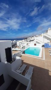 a view of a swimming pool on top of a building at The White Dragos with sea view - private pool in Tías