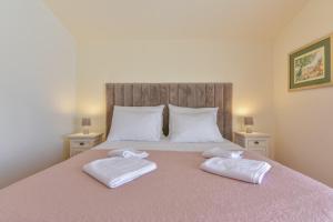 een slaapkamer met een groot bed en 2 witte handdoeken bij Apartment Marija Bibinje Zadar in Bibinje